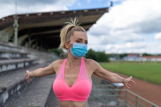 Woman takes off medical facemask after outdoor training or runni