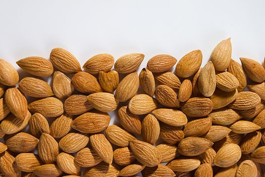 Lots of almond nuts on white background