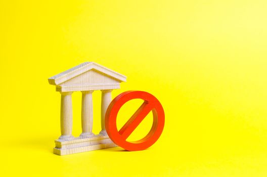Government building or bank and symbol NO on an yellow background. The concept of prohibiting and restrictive laws. Bans and criminalization, repression. Revocation of a bank license nationalization