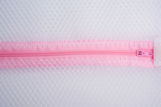 pink plastic zipper on the laundry bag, full frame