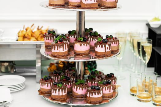 Three tier tray with cakes on the banquet table. Holidays and events.