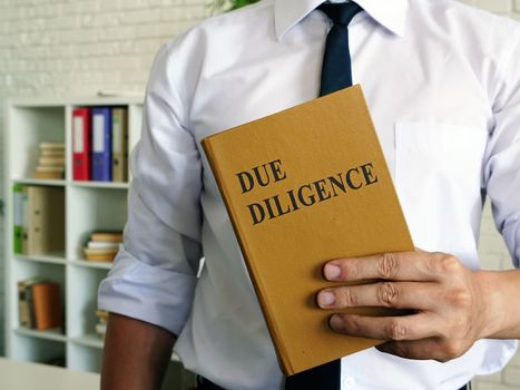 The manager shows Due Diligence book in the office.