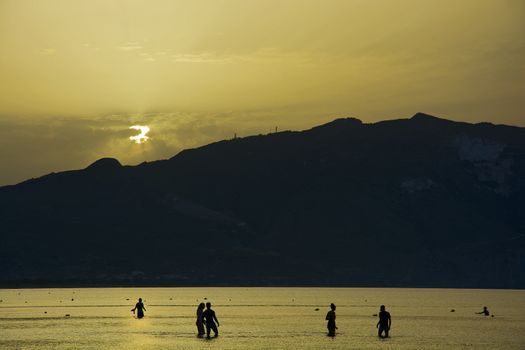 People bathe in the sea at sunrise