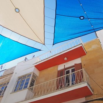 detail of a painted colourful street in the center of nicosia cyprus with blue and white shades covering the the road in bright summer sunlight
