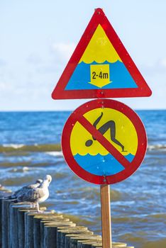 Groin in the Baltic Sea with danger sign