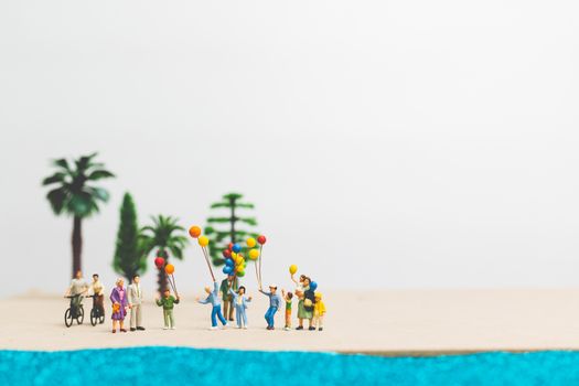 Miniature people : happy family enjoy summer vacation on the bea