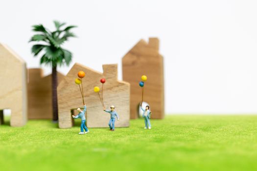 Miniature people : Happy family walking in field with balloons