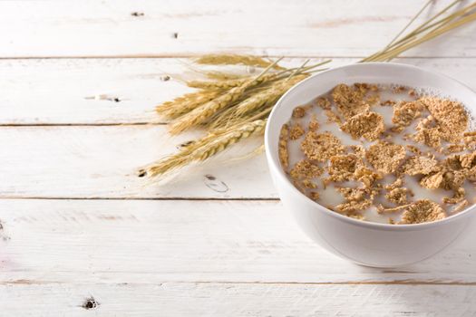 Oats milk and cereals on white wooden table.