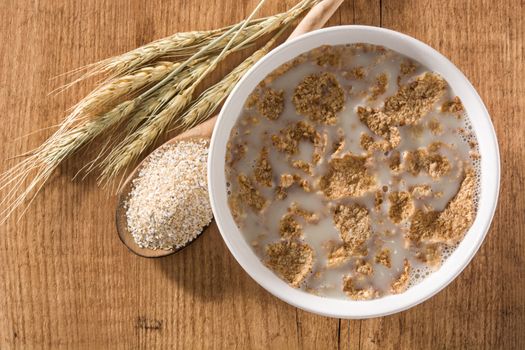 Oats milk and cereals on wooden table.