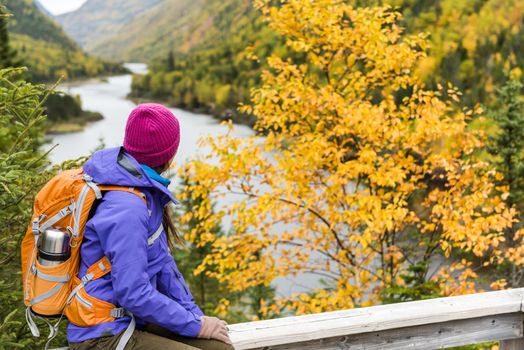 Woman hiker hiking looking at scenic view of fall foliage mountain river landscape . Adventure travel outdoors person standing relaxing at viewpoint during nature hike in autumn season.