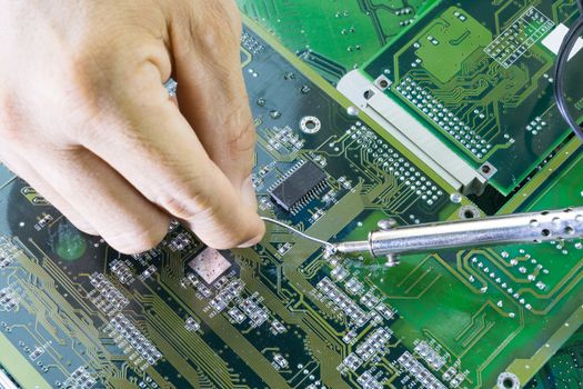 Technicians are using a soldering iron for repairing electronic 