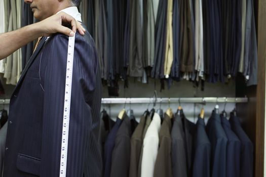 Tailor measuring business man for suit side view