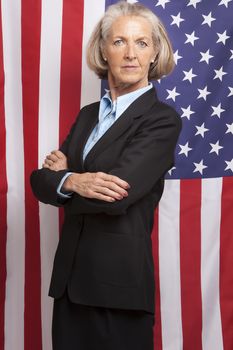 Portrait of senior businesswoman standing against american flag