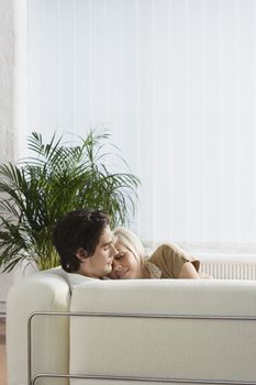 Young couple hugging napping on sofa