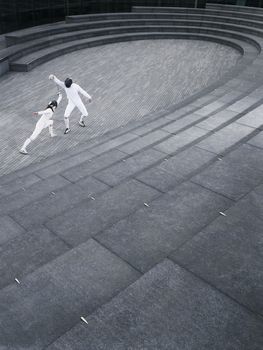 Two athletes fencing in the Scoop amphitheatre London England elevated view