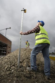 Surveyors using theodolite on building site