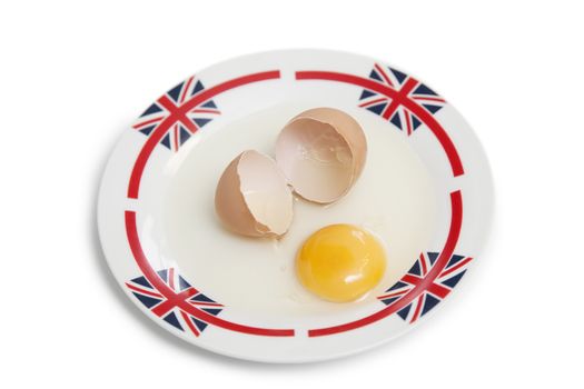 Broken brown egg on plate over white background