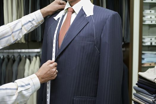 Tailor measuring business man for suit mid section