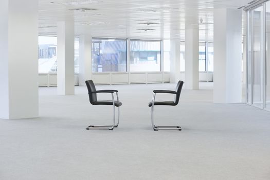 Two facing chairs in empty office space
