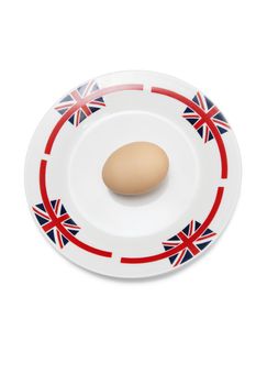 Brown egg in plate against white background