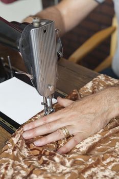 Male tailor stitching cloth on sewing machine