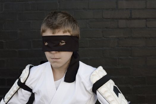 Boy wearing Zorro blindfold and fencing costume