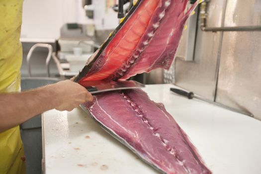Man cutting fish with kitchen knife