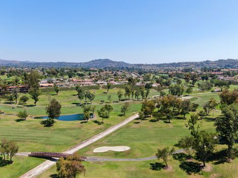 Aerial view of golf in upscale residential neighborhood.