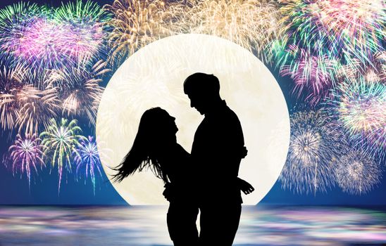 Romantic young Couple hug on the beach and fireworks background