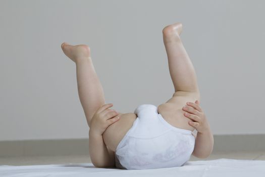 Baby girl playing on floor upside-down