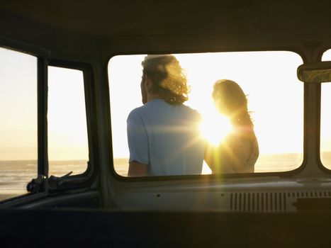 Young couple on Beach view through camper van