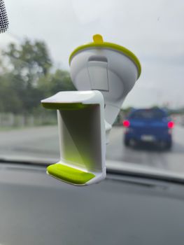 white green blank smartphone holder stuck in the windscreen of a