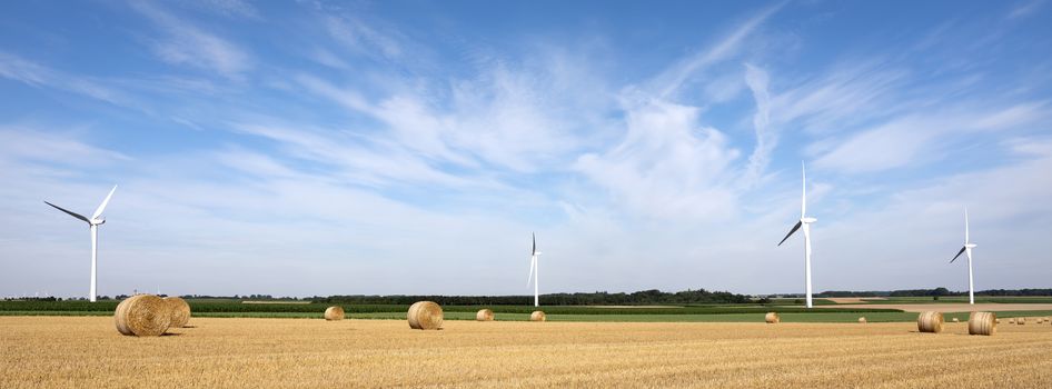 fields and wind turbine in the north of france under blue sky