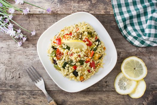 Couscous with vegetables on wooden table