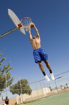 Basketball player mid-air dunking ball