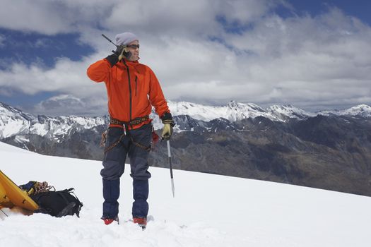 Hiker using walkie-talkie on snowy mountain peak