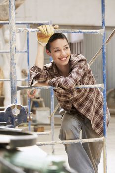 Female interior decorator leaning on Scaffolding