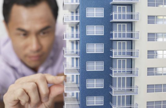 Mid adult man inspecting architectural model close-up
