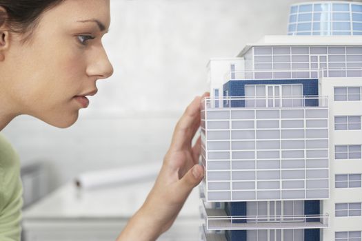 Mid adult woman inspecting architectural model profile close-up
