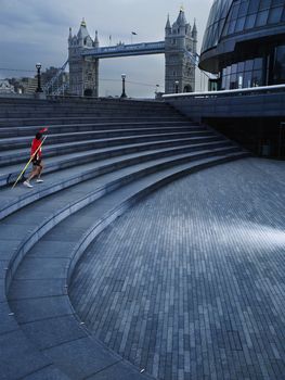 Male runner running along steps of the Scoop amphitheatre London England