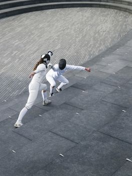 Two athletes fencing on steps of the Scoop amphitheatre London England elevated view