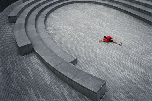 Man stretching in the Scoop amphitheatre London England elevated view