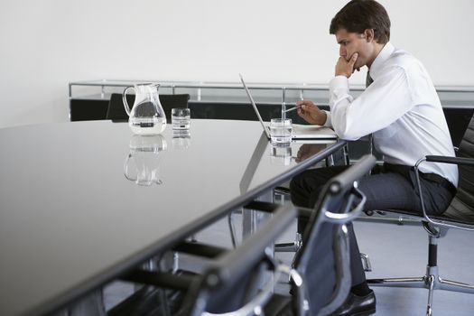 Business man using laptop at conference table