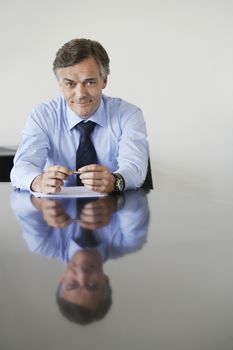 Business man sitting at conference table portrait