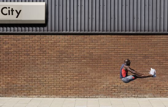 Man jumping by wall with 'city' written on it