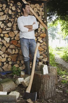 Man standing beside axe at timber shed portrait