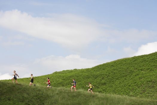 Group of people jogging up hillside