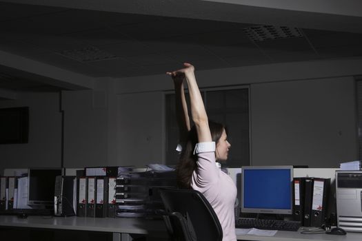 Woman stretching in office side view