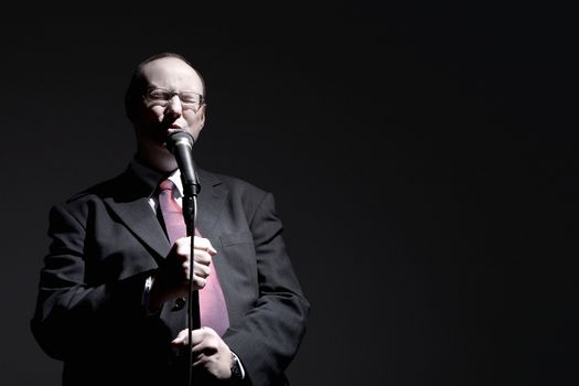 Man in full suit singing into microphone