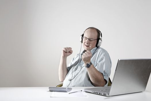 Businessman with earphones relaxing at desk